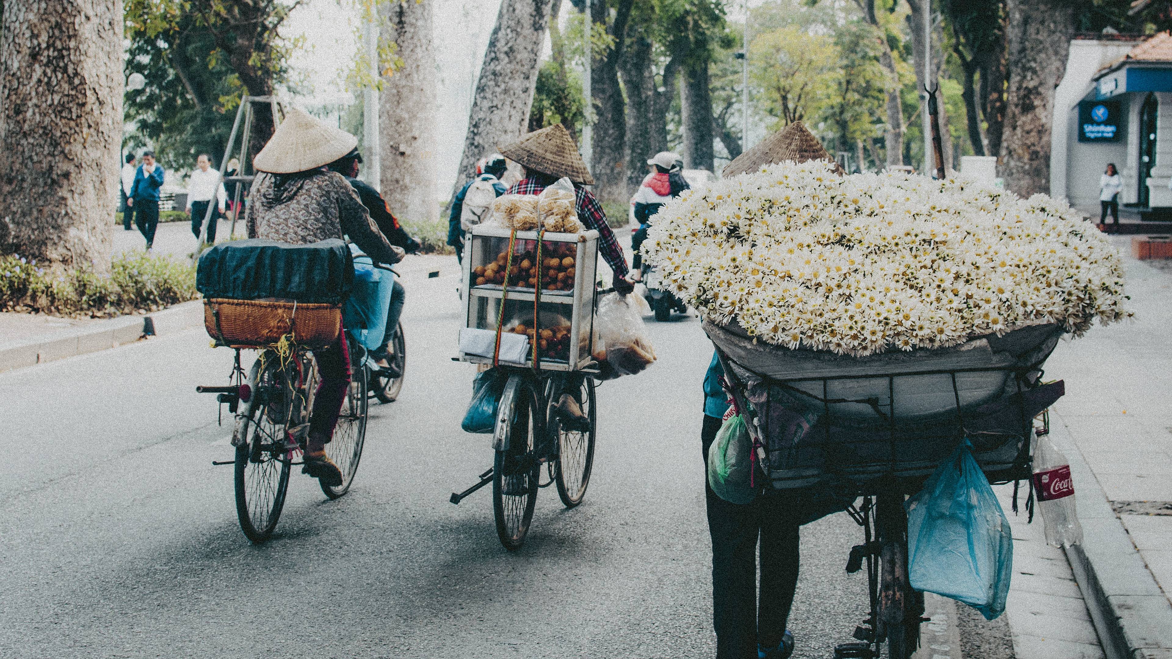 Vietnamiens en vélo transportant des marchandises