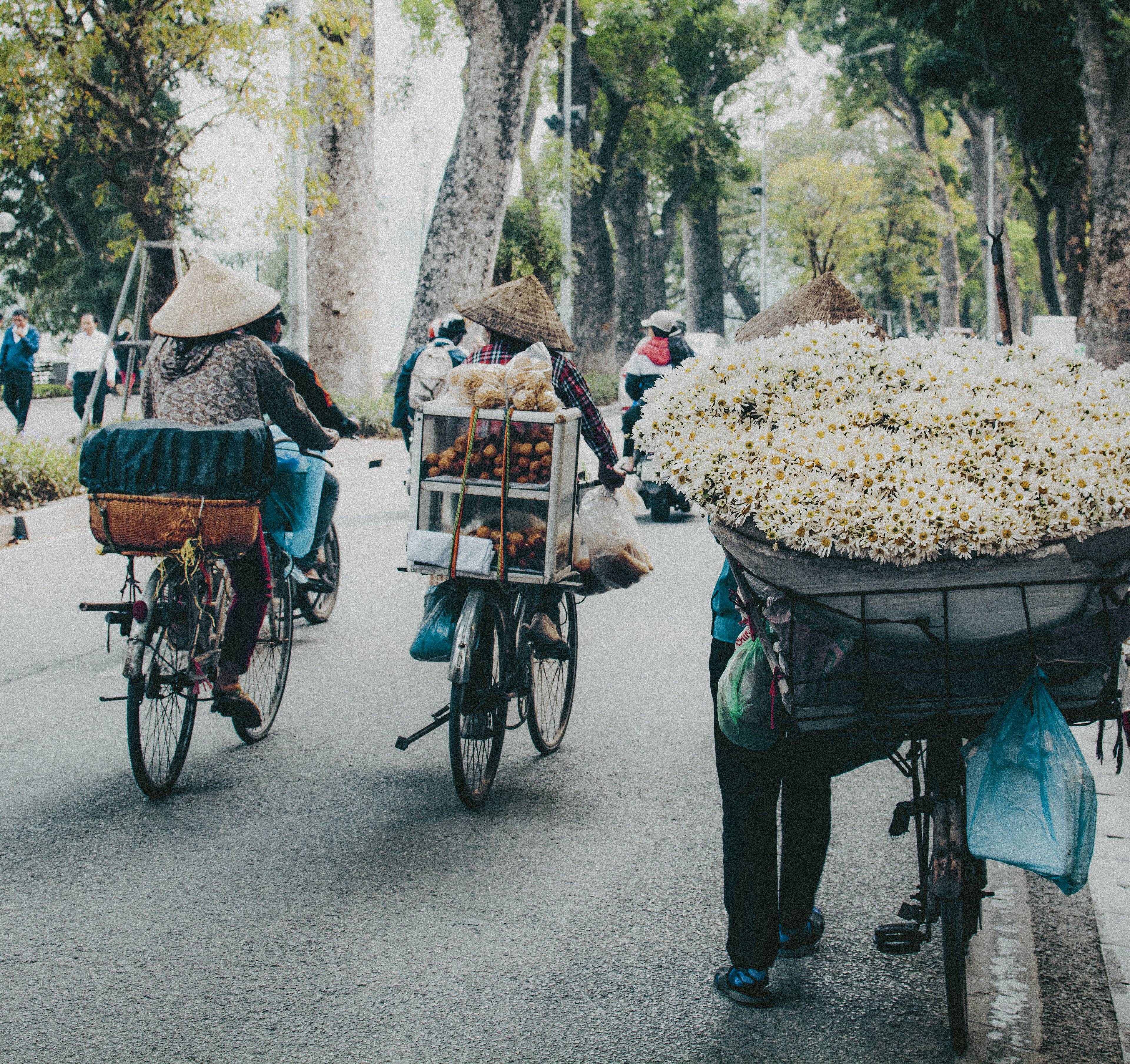 Vietnamiens en vélo transportant des marchandises