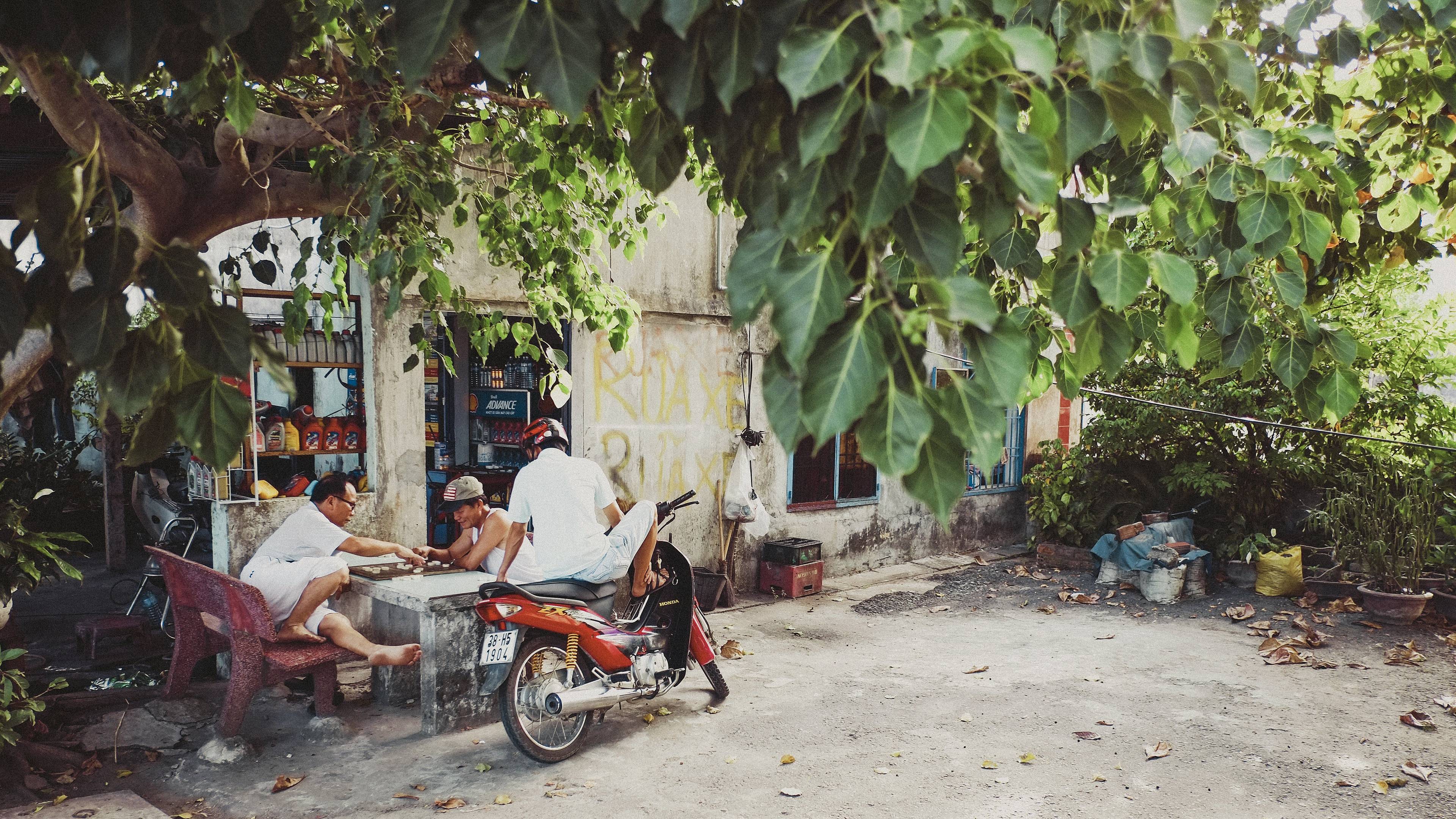 Vietnamesen spielen Go-Spiel vor einem Geschäft